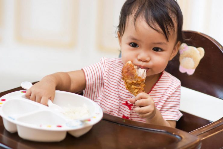 bimba che mangia pollo