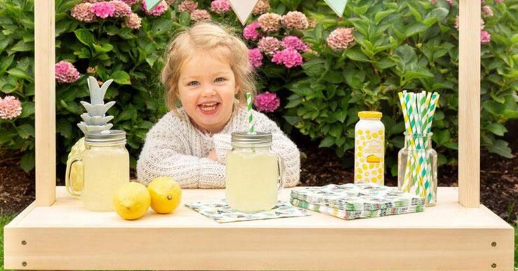 Bambina con chiosco per limonata