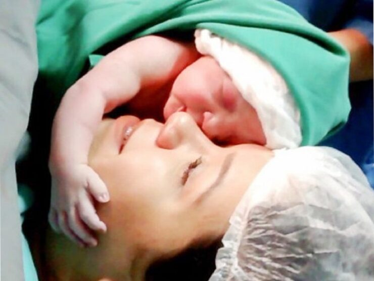Neonato abbraccia il viso della mamma pochi secondi dopo essere nato