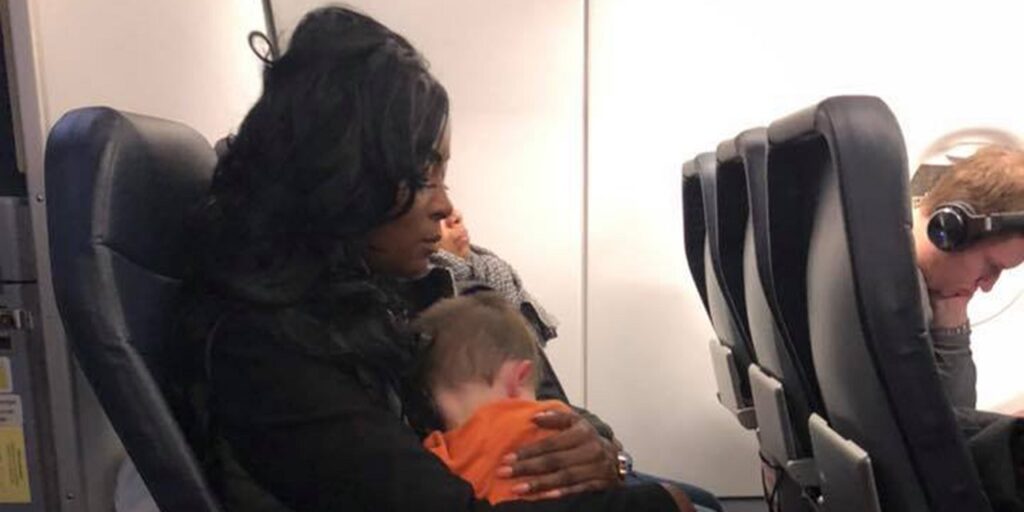 donna con un bambino in braccio in aereo